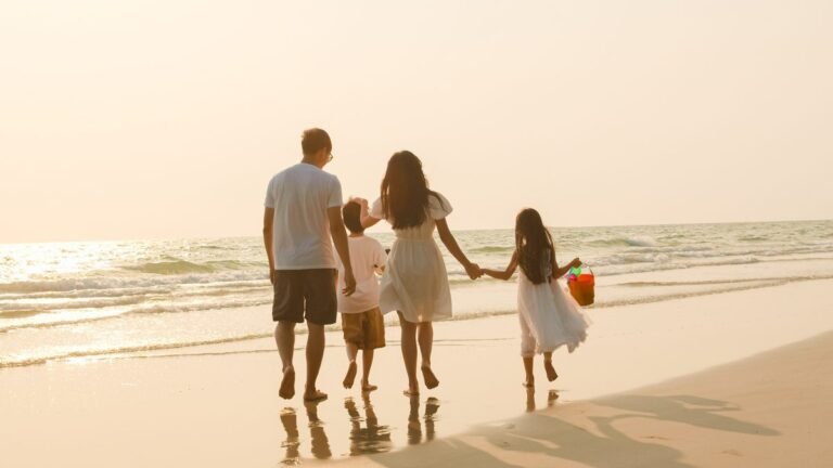 Parents and their children walking along the beach in Spain
